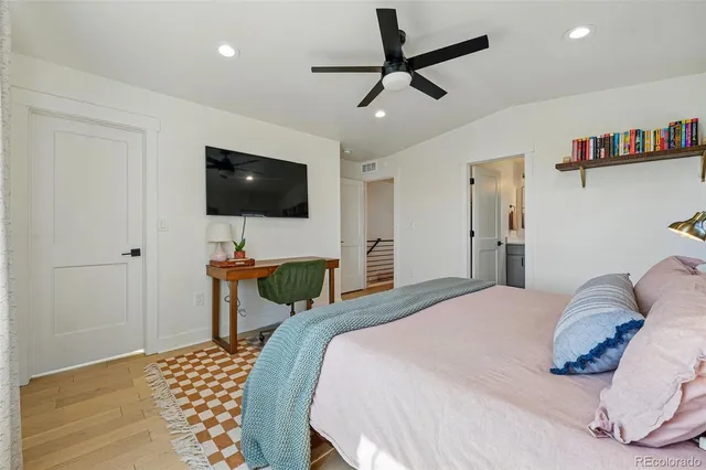 a bedroom with a bed a flat screen tv and a chandelier