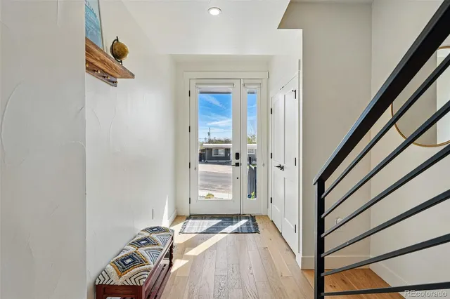 a view of a hallway with wooden floor and staircase