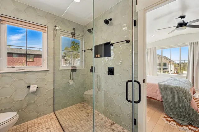 a bathroom with a granite countertop sink mirror and shower
