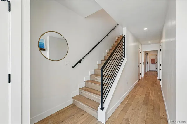 a view of a hallway with wooden floor and staircase