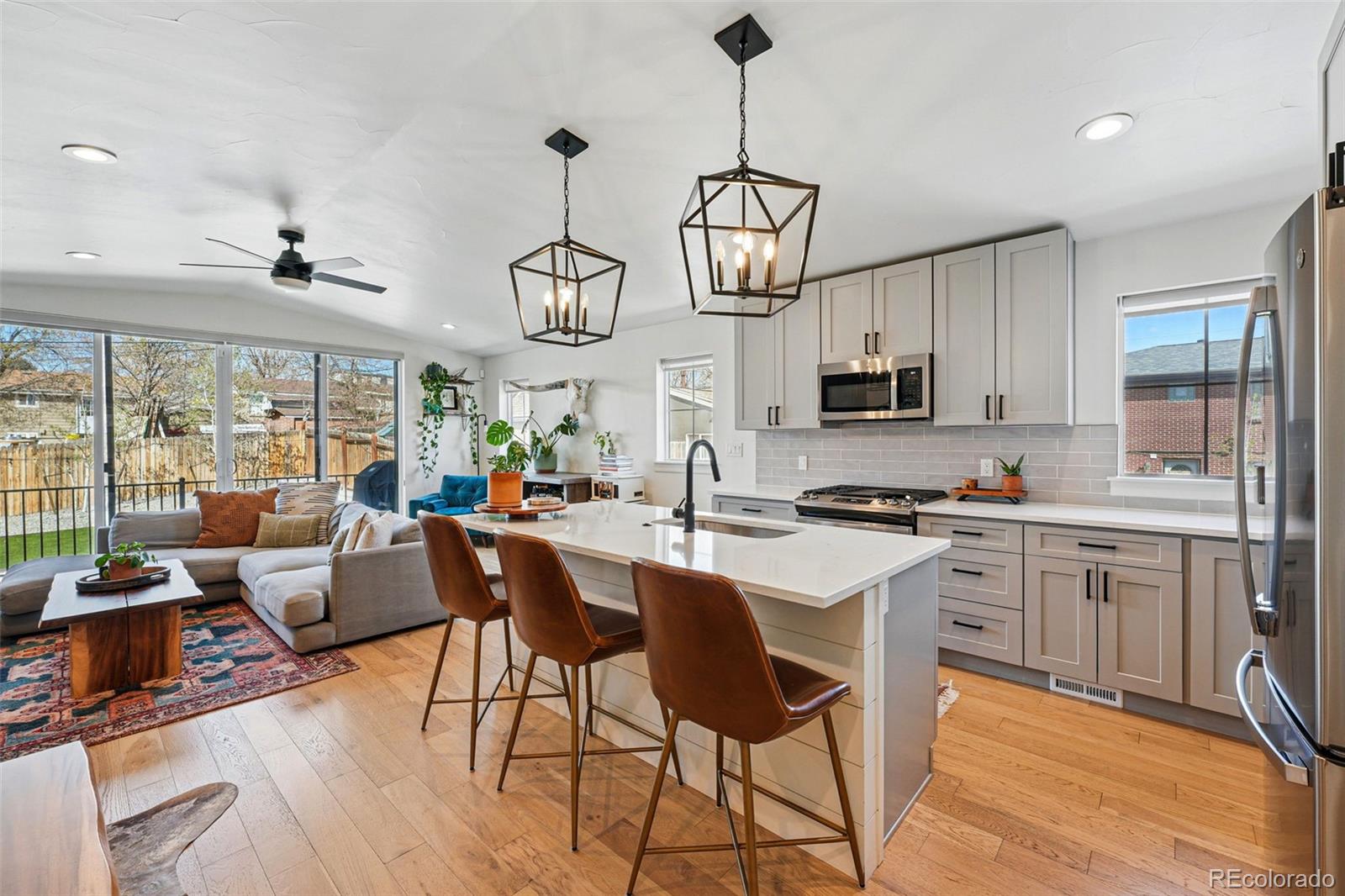 949 Raleigh Street, Unit 2 Denver, CO 80204 - Photo 3 of 42 a open kitchen with stainless steel appliances granite countertop a stove a sink dishwasher a dining table and chairs with wooden floor