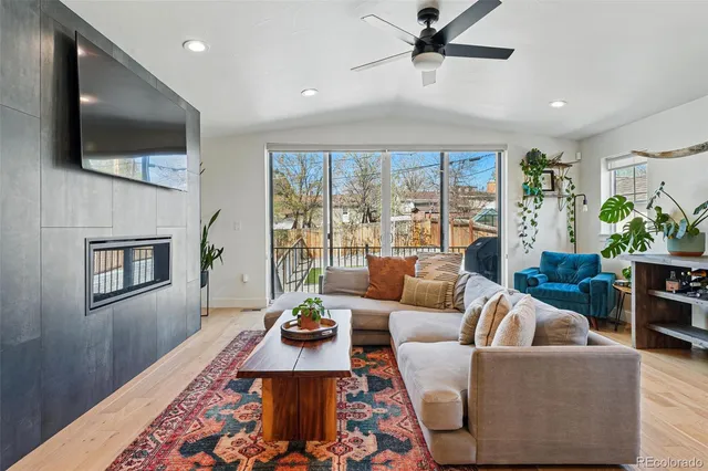a living room with furniture a flat screen tv and a fireplace