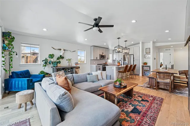 a living room with furniture kitchen view and a window