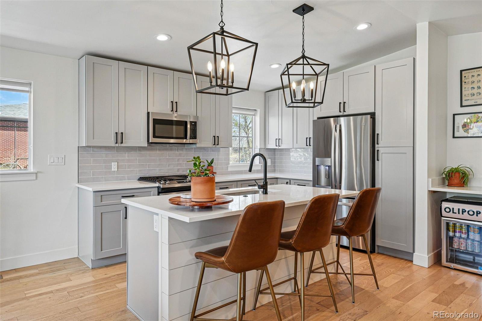 949 Raleigh Street, Unit 2 Denver, CO 80204 - Photo 9 of 42 a kitchen with stainless steel appliances granite countertop a dining table chairs refrigerator and microwave