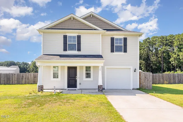 a front view of a house with a yard and garage