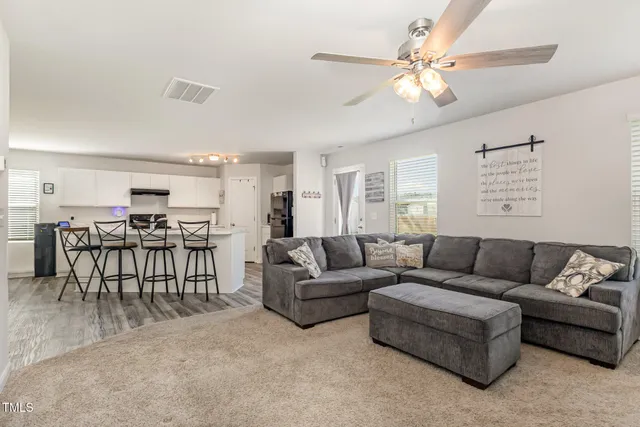 a living room with furniture and kitchen view