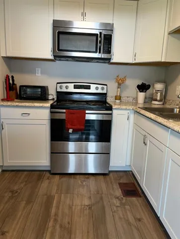 a kitchen with granite countertop a stove and a microwave