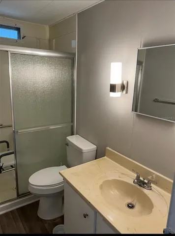 a bathroom with a sink a toilet and shower