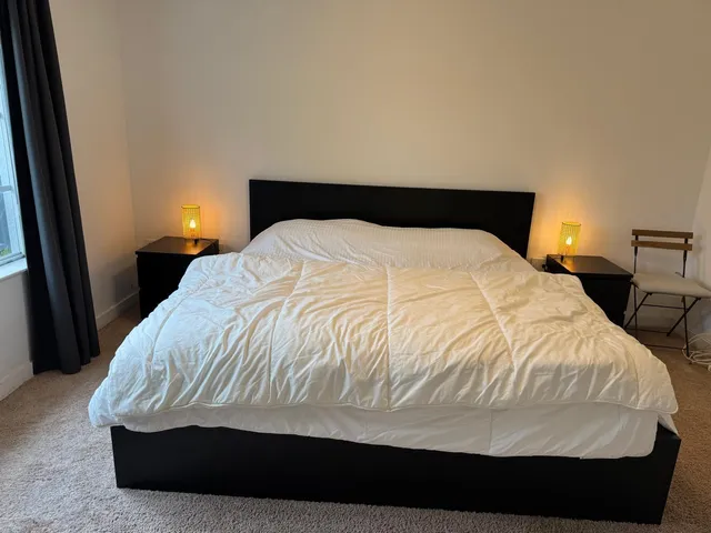 a large bed sitting in a bedroom next to a lamp