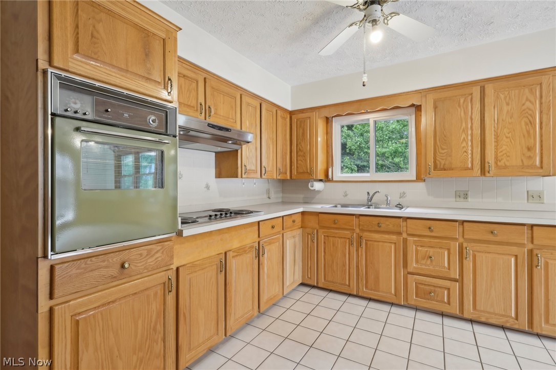 3873 Baumberger Road Stow, OH 44224 - Photo 8 of 50 Kitchen with ceiling fan, light tile flooring, a textured ceiling, oven, and sink