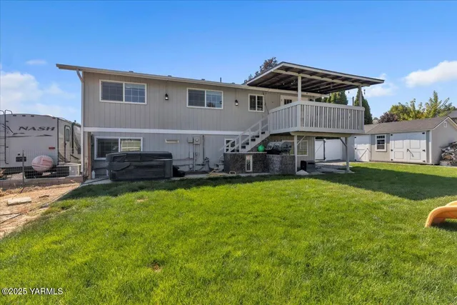 a view of a backyard with potted plants and large tree