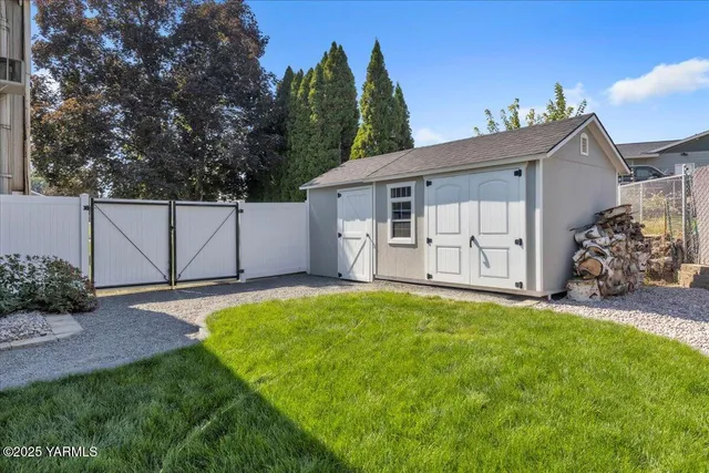 an aerial view of a residential house with outdoor space and seating area