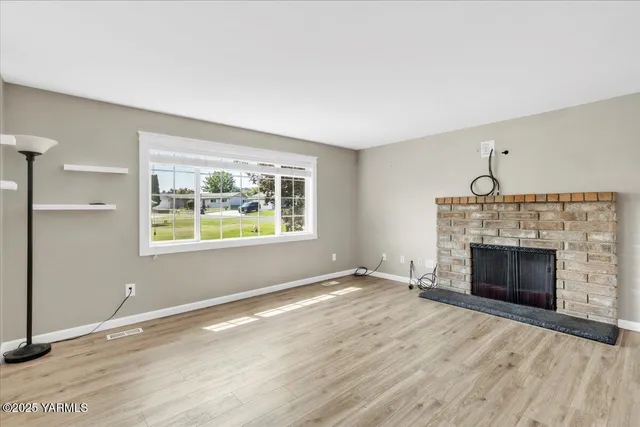 wooden floor fireplace and windows in an empty room