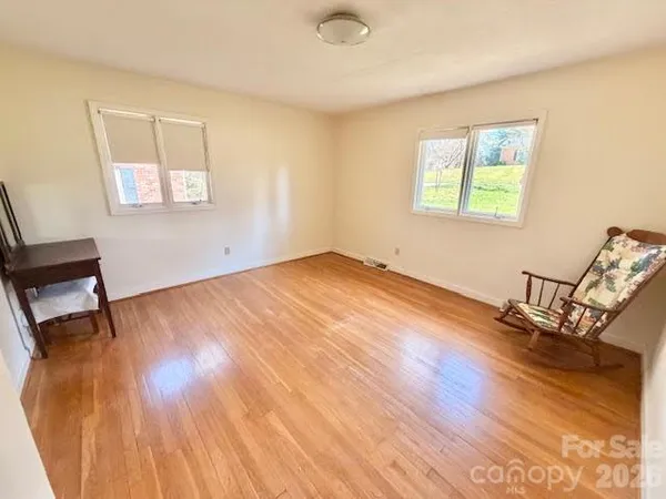 a view of a room with wooden floor and a window