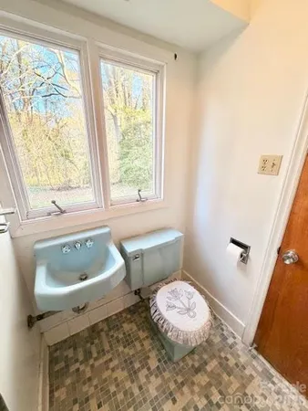 a bathroom with a sink toilet and window