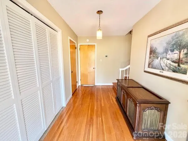 a view of a hallway with wooden floor and staircase