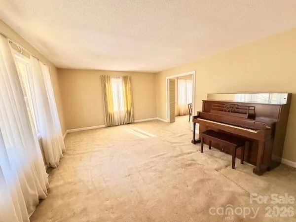 a living room with furniture and a piano