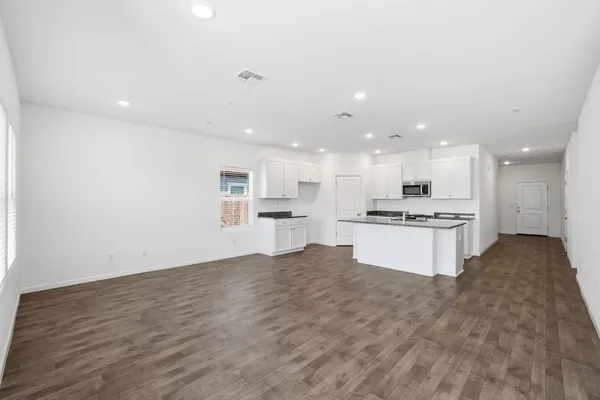 a view of kitchen with kitchen island a sink a stove and a refrigerator