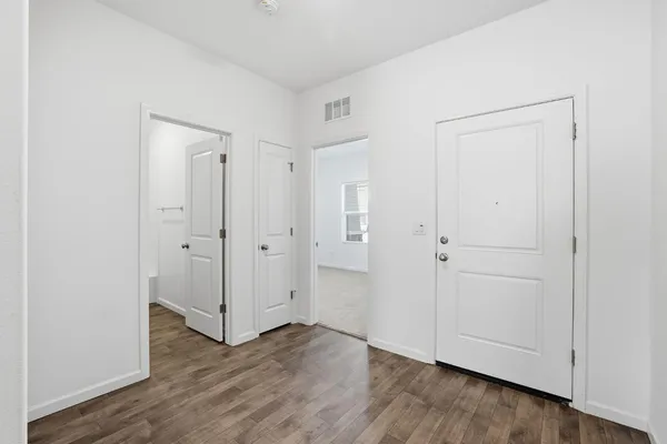 a view of an empty room with wooden floor