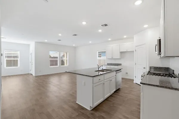 a kitchen with granite countertop a sink and a stove top oven
