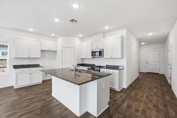a kitchen with stainless steel appliances granite countertop a stove a sink and a refrigerator