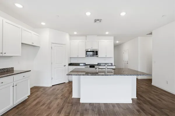 a large kitchen with stainless steel appliances granite countertop a stove a sink and a refrigerator