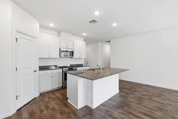 a kitchen with stainless steel appliances granite countertop a sink and a stove top oven