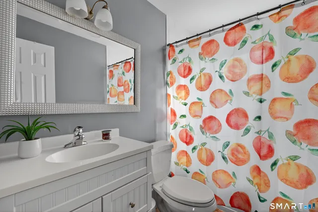 a bathroom with a sink a toilet and mirror on the wall