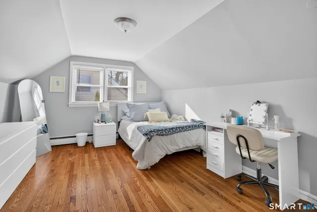 a bedroom with a bed and a wooden floor