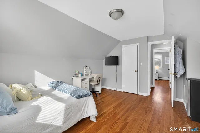 a bedroom with a bed and wooden floor