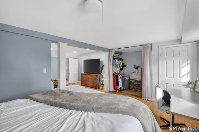 a bedroom with bed and a flat tv screen