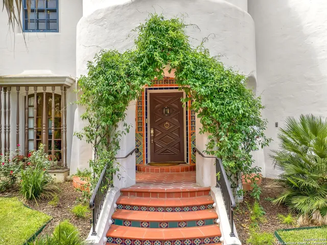 a front view of a house with plants