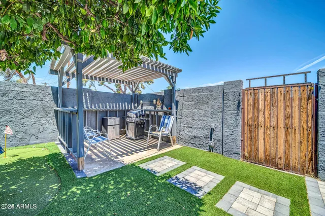 a view of a chair and table in backyard of the house