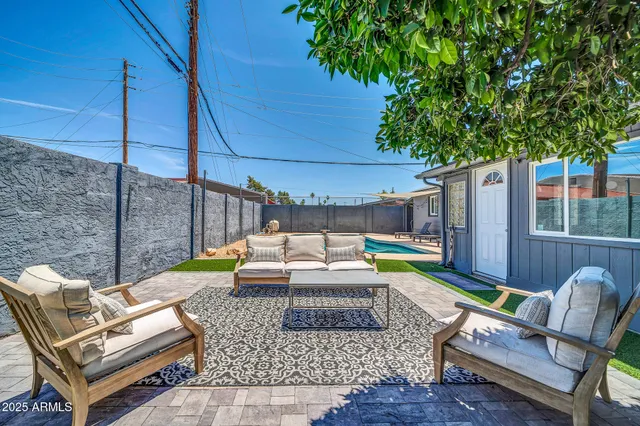 a view of a backyard with chairs and a potted plant