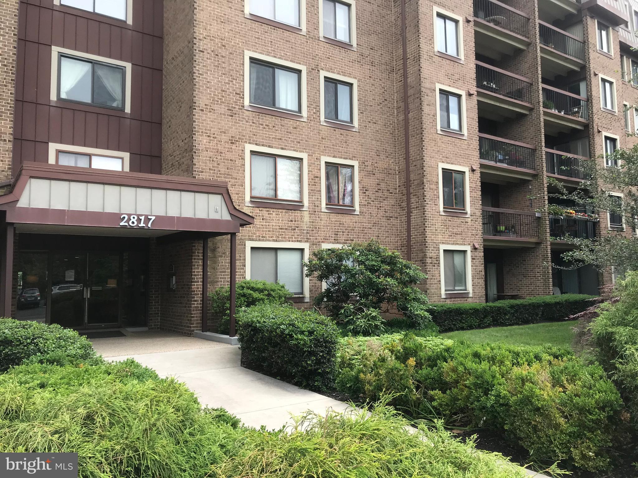 2817 Jermantown Road, Unit 203 Oakton, VA 22124 - Photo 2 of 22 a view of a brick building with many windows and a yard