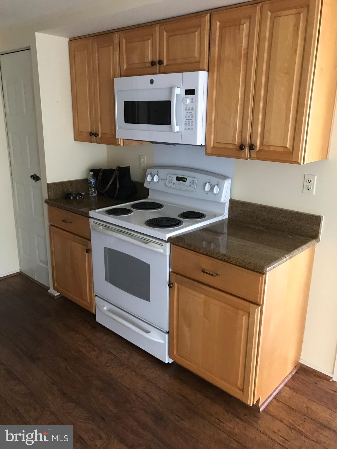 2817 Jermantown Road, Unit 203 Oakton, VA 22124 - Photo 6 of 22 a kitchen with a stove and a microwave