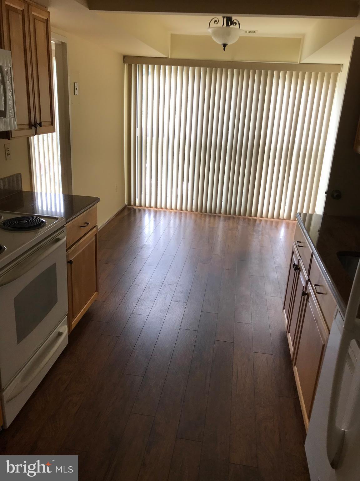 2817 Jermantown Road, Unit 203 Oakton, VA 22124 - Photo 8 of 22 a view of a livingroom with wooden floor and a window