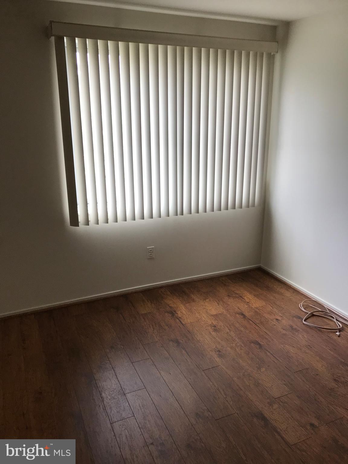2817 Jermantown Road, Unit 203 Oakton, VA 22124 - Photo 10 of 22 an empty room with wooden floor and windows