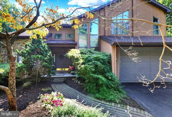 a view of a wooden house with a bench in garden