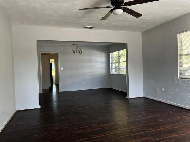 an empty room with wooden floor and a window