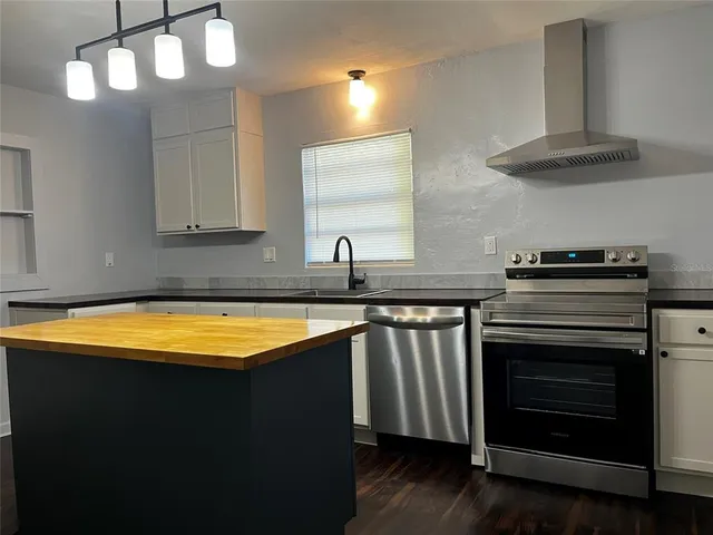 a kitchen with stainless steel appliances a stove a sink and a refrigerator