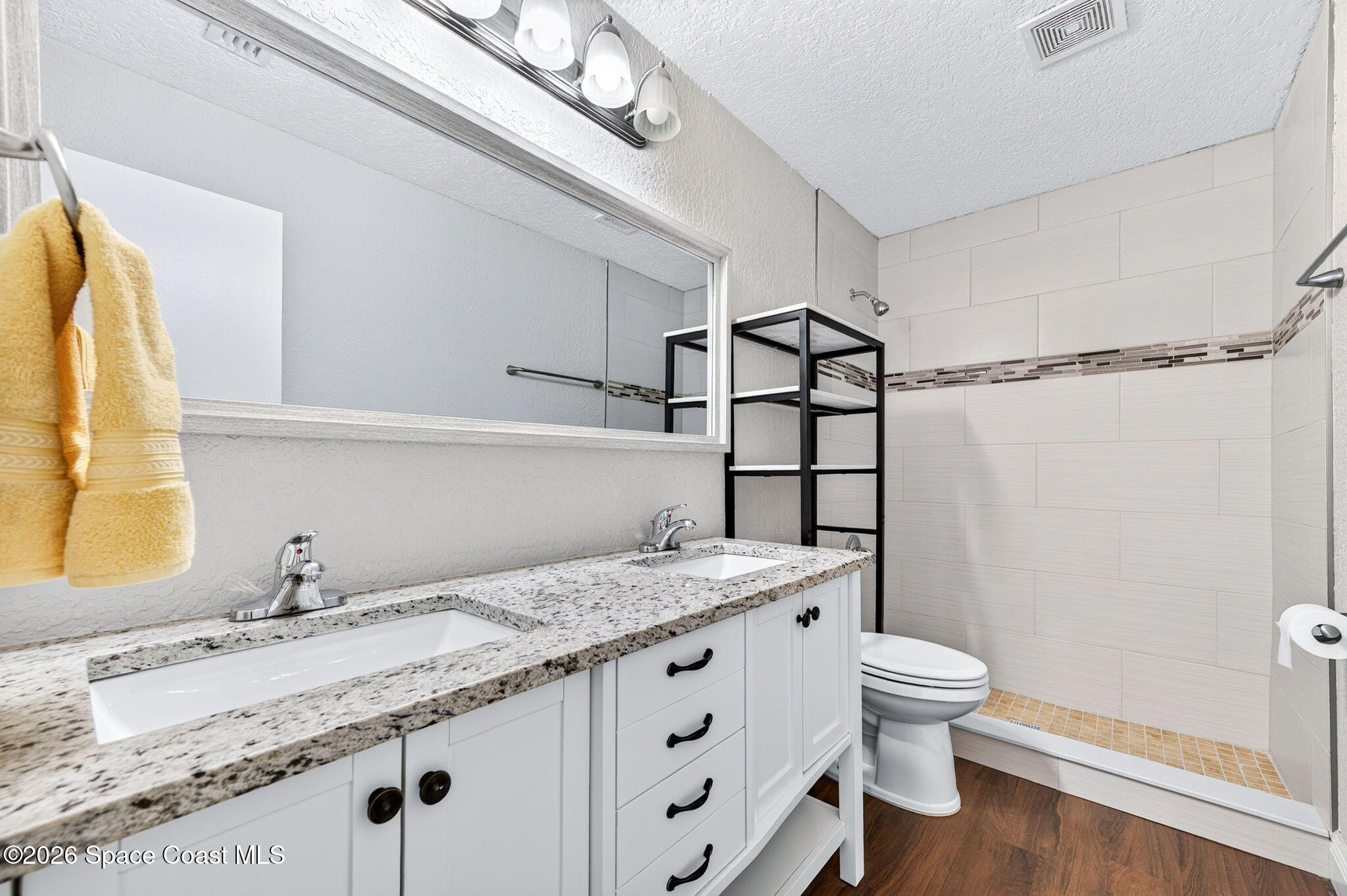 996 Botany Lane Rockledge, FL 32955 - Photo 27 of 35 a bathroom with a granite countertop sink a toilet and shower