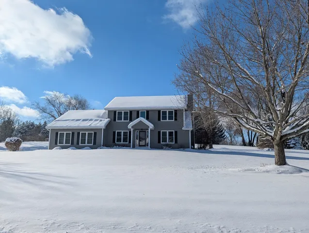 a view of a house with a yard covered in snow