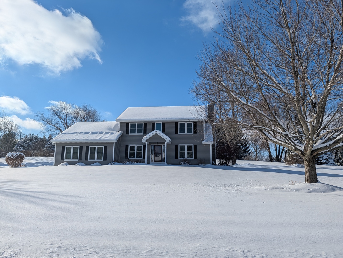 a view of a house with a yard covered in snow