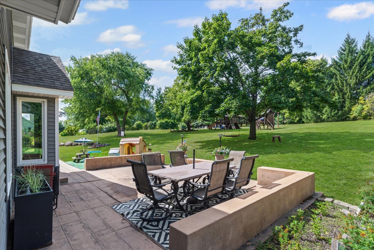 11111 Huron Drive Spring Grove, IL 60081 - Photo 18 of 20 a view of a patio with table and chairs potted plants with palm trees
