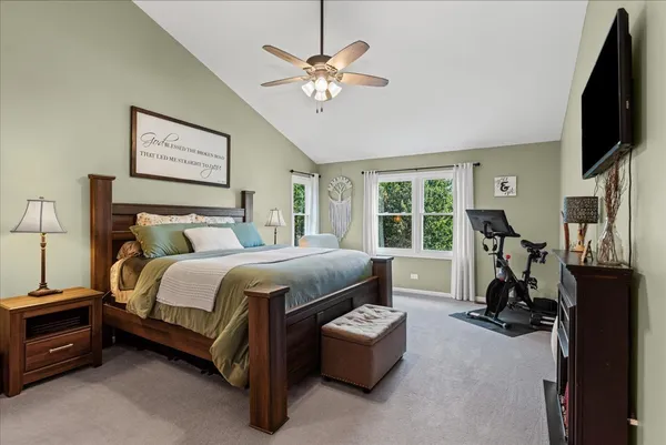 a bedroom with bed tv and a window