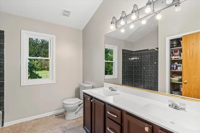 a bathroom with a sink a large mirror and a toilet