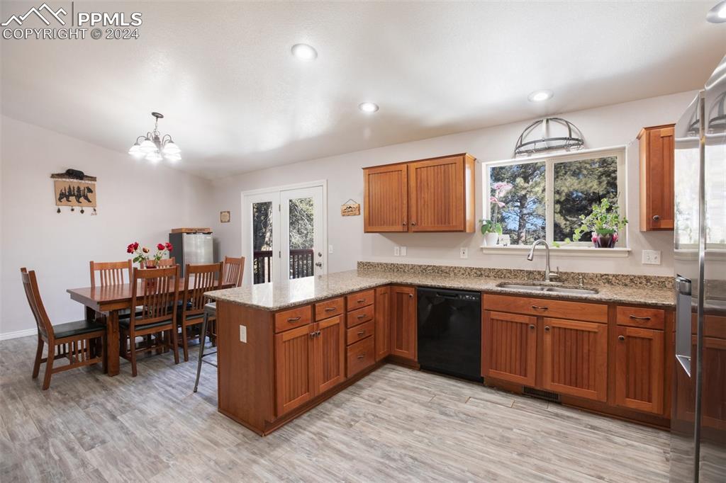 833 Spring Valley Drive Divide, CO 80814 - Photo 16 of 50 a open kitchen with stainless steel appliances granite countertop a sink dishwasher a stove and a dining table with wooden floor
