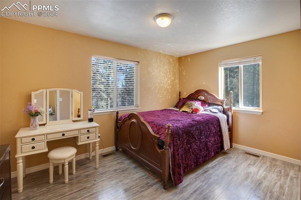 833 Spring Valley Drive Divide, CO 80814 - Photo 28 of 50 a bedroom with a bed a chandelier and a window