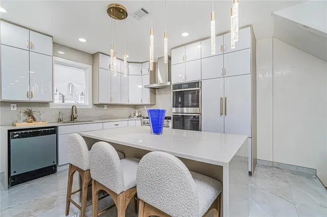 a kitchen with stainless steel appliances granite countertop a table chairs sink and cabinets
